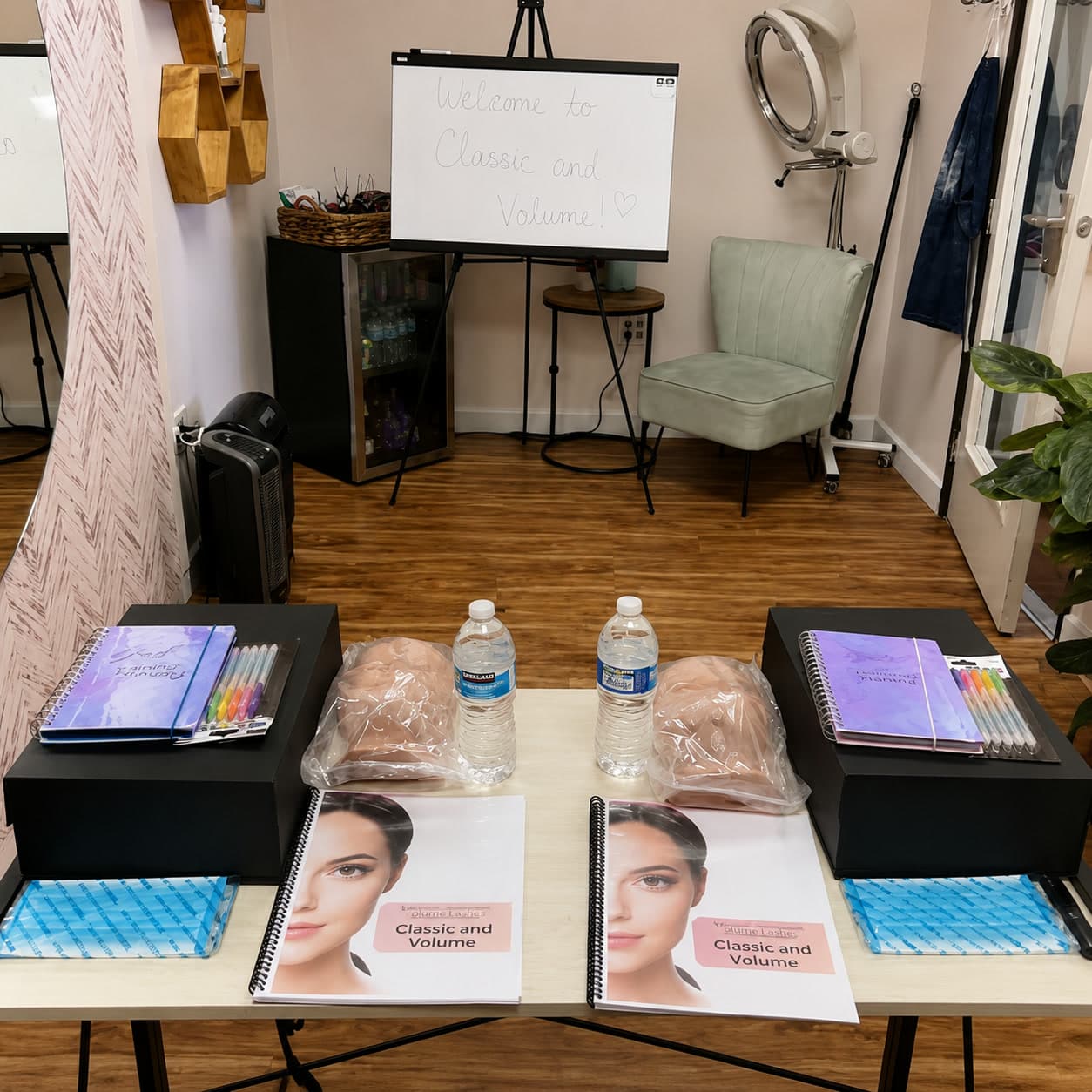 Training stations set up for a lash lesson with mannequin heads, manuals, and supplies at Anahit's studio